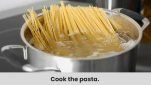 Linguine pasta being added to a pot of boiling water.