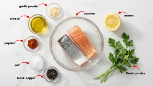 Ingredients for making crispy air fryer salmon, including salmon fillets, olive oil, garlic powder, paprika, dill, salt, pepper, and lemon – Tasty Recipe Zone.