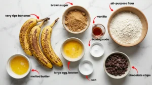 Complete banana bread ingredients including ripe bananas, flour, brown sugar, butter, eggs, baking soda, salt, vanilla extract, and chocolate chips.
