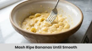 Mashed ripe bananas in large mixing bowl for homemade banana bread