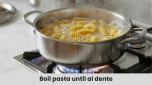Boiling gluten-free pasta in a large pot of salted water as the first step to making easy gluten-free pasta salad