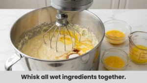 Mixing wet ingredients for the King Cake recipe dough in a stand mixer.
