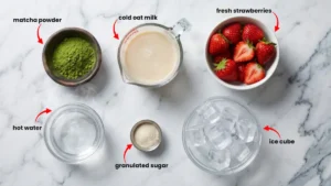 Fresh ingredients for Starbucks strawberry matcha latte including strawberries, matcha powder, oat milk, and lemon.