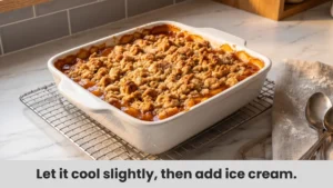 Freshly baked peach crisp with golden brown topping cooling on wire rack, showing bubbling peach filling