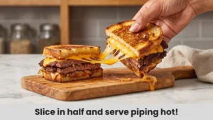 Serving smash burger patty melt cut in half with melted cheese stretching between halves