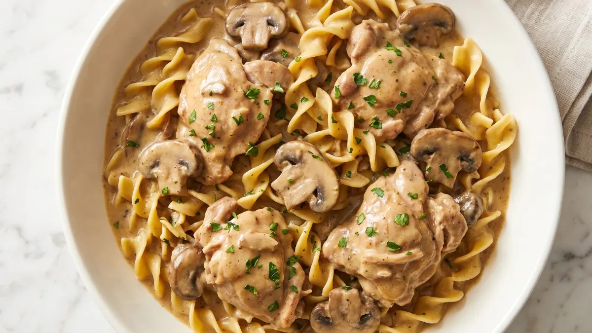 Creamy chicken stroganoff with tender chicken, mushrooms, and fresh parsley served over egg noodles.