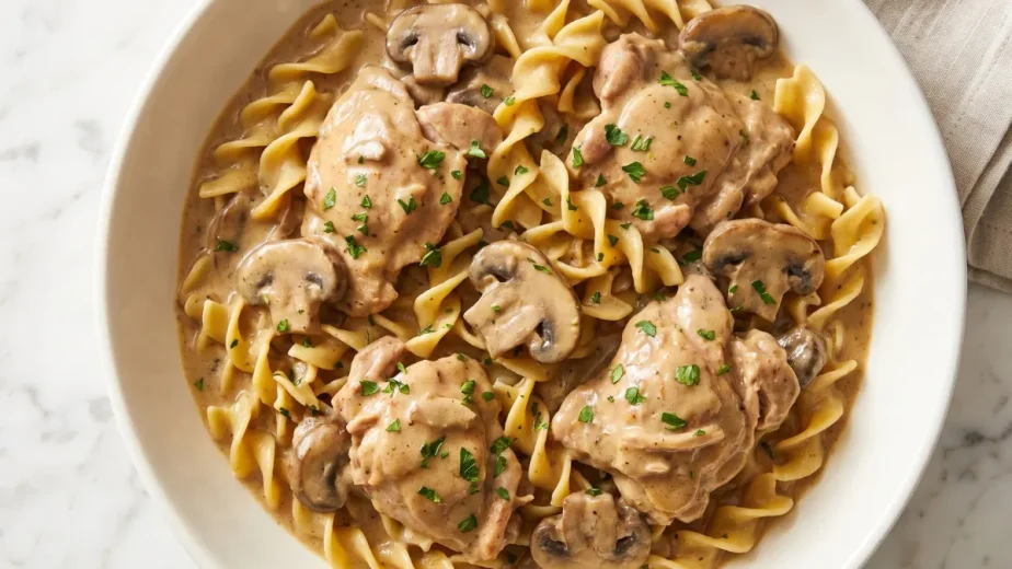 Creamy chicken stroganoff with tender chicken, mushrooms, and fresh parsley served over egg noodles.